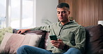 Reading, relax or man with phone on couch, check digital photo album or typing response for web chat. Texting, chill or person with smile for message notification, mobile or browsing internet in home