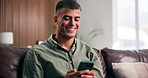 Reading, relax or man with phone on sofa, check digital photo album or typing response for web chat. Texting, chill or person with smile for message notification, mobile or browsing internet in home