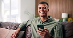 Face, smartphone and man in home, smile and digital app for social media, relax and texting. Apartment, mobile user and person on sofa, internet and cellphone for communication and message to contact