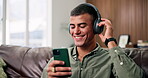 Headphones, dance and man with phone on couch, online radio channel and listening to weekend playlist. Smile, audio tech and person with music app subscription for streaming, home and moving to beat