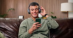 Headphones, dancing and man with phone on couch, online radio channel or listening to weekend playlist. Home, tech or happy person with music app subscription for streaming, singing or moving to beat