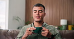 Aroma, coffee and thinking with happy man on sofa in home living room for break or inspiration. Drink, smile and scent with person in apartment to relax for caffeine, me time chilling or unwind