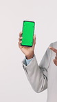 Businessman, hands and green screen with phone in studio for advertising on a white background. Man, user or model pointing with mobile smartphone display or chromakey for online marketing or app