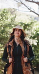 Woman, hiking and adventure in nature with backpack, sightseeing and vacation activity for wellness. Bokeh, person trekking or journey outdoor with bag for forest exploration, travel or tourist trip.