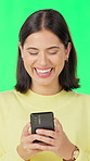 Phone, laugh and woman by green screen for texting, communication or email on mobile app. Happy, technology and person with cellphone for chatting, social media or blog online by studio background.