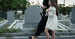 People, child and walking at cemetery with flowers, funeral and burial ceremony for final goodbye. Family, girl and grieving together in graveyard with rose, memorial service or compassion for death.