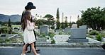 People, child and walking at graveyard with flowers, funeral and burial ceremony for final goodbye. Family, girl and grieving together at cemetery with rose, memorial service or compassion for death.