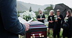 Funeral, hands or priest with bible at graveyard, memorial service or scripture for religious practice. Reading, Christianity or people with pastor for farewell ceremony, casket or burial prayer