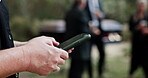 Funeral, typing and hands in cemetary with phone, family arrangements or update on reception details. Text, bokeh and woman outdoor with tech, ceremony schedule or online chat at memorial service.