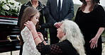 Child, sympathy and senior woman by coffin for funeral at cemetery, graveyard or outdoor for farewell. People, orphan or family together for grief, death and respect or support with condolences
