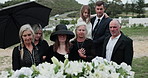 Sad, people and child with casket at graveyard for funeral ceremony, burial service and mourning loss. Family, embrace and kid with grief, goodbye ritual and tribute gathering at farewell memorial 
