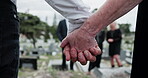 Graveyard, people and holding hands for memorial service, family mourning and compassion for comfort. Sympathy, care and senior woman with son for emotional support, loss and grieving at cemetery