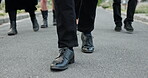 People, feet and walking at cemetery with funeral procession, solidarity and burial ceremony outdoor. Person, shoes and journey in graveyard with family mourning, memorial service and grief together.