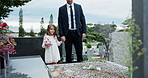 Girl, father and flower in cemetery for funeral, spiritual comfort or tombstone for respect. Mourning, family and support for child in graveyard with grief, loss or farewell with ritual or blessing