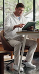 Creative, scroll and man in home, tablet for online submission and ideas for manuscript. Remote work, freelancer and person in lounge, internet and tech for news report and email for article review