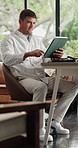 Tablet, reading and man in home office for remote work, review headline or report for news. Technology, scroll and freelance journalist in house for story research, editing article or fact check