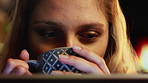 Night, woman and drinking tea in home with laptop, watching movie or online entertainment on weekend. Evening, female person and relax in house with computer, beverage and streaming service for film.