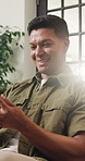 Happy, man and texting with smartphone in lounge, reading and communication with contact on website. House, flare and person with mobile app for chat, laughing or review funny message on social media