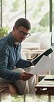 Document, tablet and man in home for remote work, budget approval or accounting with audit. Technology, living room or freelance accountant with paperwork for financial report, reading or bookkeeping