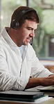 Call center, headset and man in home, talking and advice for customer service, system solution and laptop. Apartment, agent and person in lounge, pc and communication for tech support and help desk