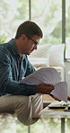 Documents, copywriting and man in home, laptop for online submission and checklist for article. Freelancer, person and journalist in lounge, remote work and editing tips for manuscript and creativity