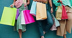 Hands, shopping bags and wall with friends outdoor together for buying, purchase or spending. Concrete, retail and sale with group of people in line for bargain, deal or discount as customer