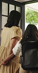 Backpack, help and mother with daughter at front door of family home for education, support and care. Back to school, student and morning routine with person and child in apartment for getting ready