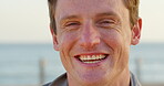 Beach, laughing and face of man on boardwalk, funny memory and travel destination for weekend trip. Portrait, spring break and happy student with vacation adventure on promenade, tourism and joke