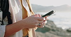 Cellphone, hands and woman by beach for travel, vacation or getaway with texting on mobile app. Technology, outdoor and female person with phone for networking, social media or chatting by ocean.