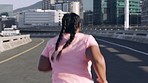 Back, exercise and running with woman on bridge in city for cardio training or workout routine. Health, ponytail and wellness with runner outdoor in urban town for challenge, fitness or pace