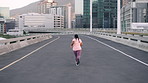 Fitness, woman and running in city for exercise, wellness and training for weight loss from back. Cardio, plus size person and runner on road outdoor for workout, health or jog for sports on bridge