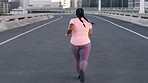 Fitness, woman and running in city for workout, wellness and training for weight loss from back. Cardio, plus size person and runner on road outdoor for exercise, health or jog for sports on bridge
