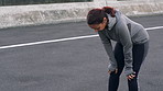 Runner, tired and woman in city, training and burnout with exercise, cardio workout and practice. Challenge, person and athlete in street, fitness for health benefits and breathing with wellness