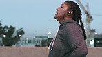 Plus size, woman and earphones in city, fitness and thinking of body goals after workout and fatigue. Streaming, music and African person with burnout on road, reflection and exercise for weight loss