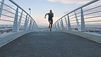 City, running and man on bridge for fitness, athlete and workout routine for body goals or wellness. Outdoor, runner and person on road for exercise, performance and training for physical health