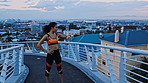 City, athlete and woman with smart watch on bridge, fitness and monitoring heart rate after exercise. Outdoor, evening and African person with tech for speed stats, cardio and workout for wellness