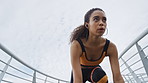 Fitness, earphones and woman in city ready for running, workout or training on bridge for wellness. Sports, audio tech and female athlete with warm up for cardio exercise with health in urban town.