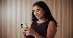 Woman, happy and texting with phone at office by wall, space and check notification at media company. Person, smile and writer on smartphone, mobile app or scroll on social network at creative agency
