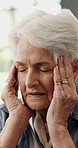 Senior woman, headache and stress in home with temple massage, fatigue or pressure in lounge. Elderly person, frustrated and migraine with chronic pain in retirement, burnout or vertigo in house
