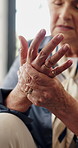 Hands, arthritis and old woman with injury in retirement home with fatigue, joint pain or carpal tunnel. Elderly person, ache and fibromyalgia with inflammation on sofa in living room of house