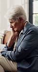 Elderly woman, sad and thinking on sofa in home with reflection, memory or trauma in living room. Old person with depression, mental health and grief on couch in lounge for retirement in house