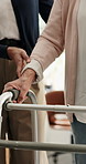 Volunteer, holding hands and walker with senior woman for support, balance or healthcare service. Assisted living, caregiver or helping elderly person with disability, arthritis and recovery in home