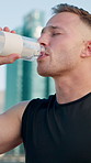 Runner, fitness and man in city with water on break for exercise, workout and training outdoor. Sports, town and person with liquid for hydration, minerals and drink for wellness, recovery and health