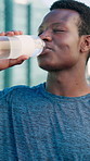 Runner, fitness and black man in city with water on break for exercise, workout and training. Sports, town and person with liquid for hydration, minerals and drink for wellness, recovery and health