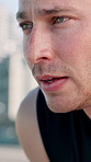 Runner, tired and man with sweat in city for exercise, cardio workout and training outdoor. Fitness, athlete and person with fatigue, rest and breathe for active hobby, wellness and health in town