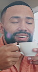 Happy, man and thinking in house with coffee, calm morning routine and contemplation for weekend break. Person, smile and smell tea in home with reflection, peace and remember memory for nostalgia.