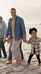 Family, holding hands and walk with children on beach, bonding and travel together on summer holiday. Ocean, adventure and interracial parents with kids in nature, outdoor and people on vacation