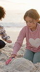 Beach, children and building sandcastle with shovel, play and relax on summer vacation. Kids, toys or holiday with soil by ocean in nature for game, development or bonding together on tropical island