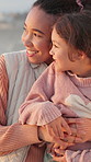 Smile, mother and hug with child at beach for travel, parental love and bonding on holiday. Happy, interracial family and embrace kid with affection, sightseeing view and support on tropical vacation