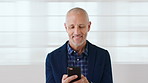 Phone, happy and mature businessman in office for email, networking or communication on mobile app. White wall, technology and male manager with cellphone for online contact in workplace by space.